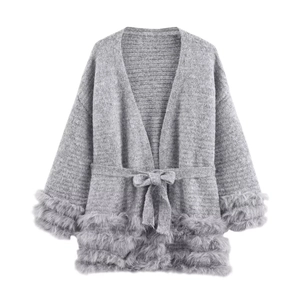 Detail der grauen Strickjacke mit Kunstpelzbesatz an Ärmeln und passendem Bindegürtel