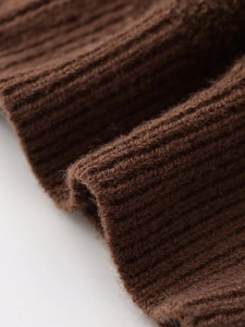 Detailed macro shot of brown ribbed knit texture on a fashionable zip-up cardigan jacket