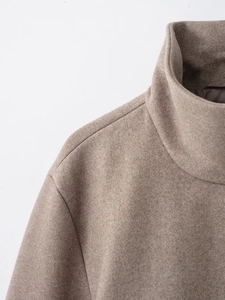 Detailed view of camel wool coat featuring a high-neck collar and shoulder stitching