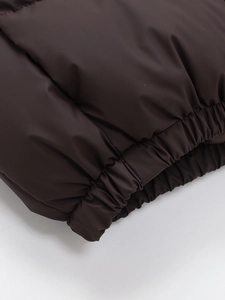 Women's minimalist solid brown puffer vest featuring an elastic hem for windproof warmth
