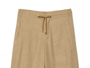 Detail of camel corduroy pants showing elastic drawstring waist and golden metal tips