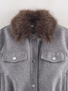 Detail view of grey wool jacket featuring a large brown faux fur collar and silver buttons