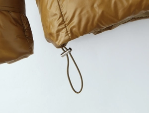 Close-up of winter puffer jacket hem with adjustable elastic drawstring and metal toggle