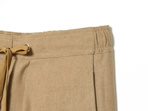 Close-up of drawstring elastic waistband and side pockets on khaki twill trousers