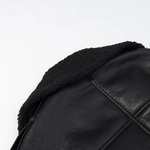 Close-up detail of black PU leather coat featuring thick sherpa lining and premium stitching