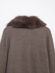 Close-up of the plush dark brown faux fur collar on the knit winter jacket for women