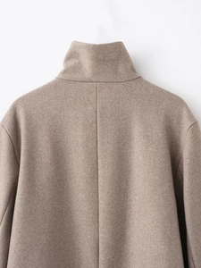 Detailed close-up of the elegant high-collar back seam on this light camel wool coat