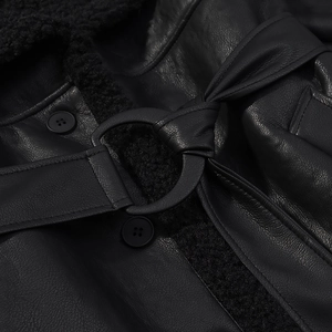 Detailed macro shot of faux leather texture and fleece lining with belt buckle detail