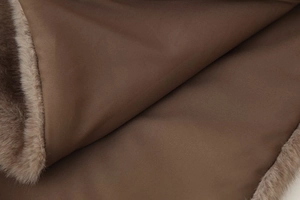 Macro shot of faux fur trim detail on brown high-neck sleeveless shawl vest fabric