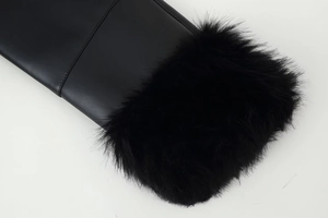 Detail shot of black faux fur trim and smooth leather texture on women's winter boots