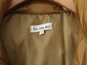 Detail view of khaki puffer jacket collar label showing size S and inner fabric texture