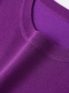 Close-up of a purple knitted sweater neckline showing ribbed collar and fine fabric texture