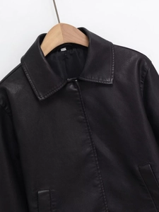 Detailed view of black PU leather jacket featuring sharp lapel collar and soft texture