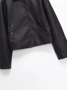 Detail of the black PU leather jacket showing the hem, wide sleeves and side pockets