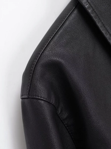 Detailed view of stitching and shoulder texture on a black faux leather jacket