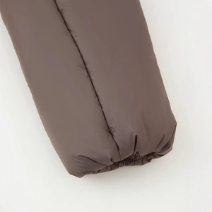 Close-up of matte brown long-sleeve cotton jacket cuff with windproof padded insulation
