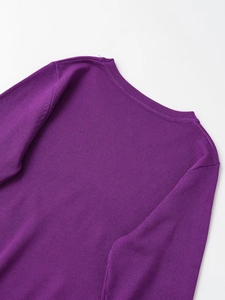 Detailed view of the fine knit texture and buttoned shoulder on this purple crewneck sweater
