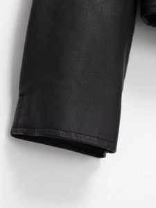 Macro detail of high-quality black PU leather texture and stitching on jacket cuff