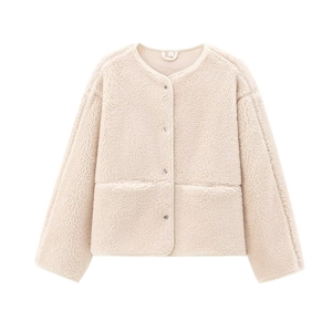 Gros plan sur la veste en polaire peluche beige avec boutons-pression et grandes poches