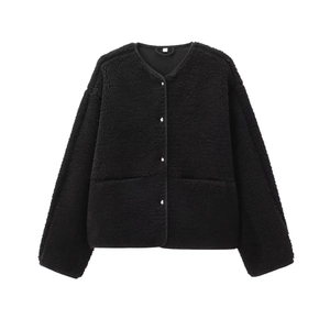 Détails de la texture du tissu de la veste teddy noire avec des boutons en métal