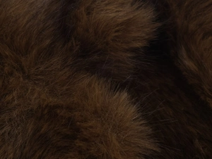 Gros plan sur la texture en fausse fourrure marron foncé montrant des fibres douces