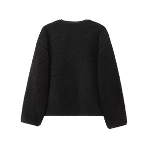 Détail de la veste en polaire sherpa noire montrant la texture granuleuse du tissu