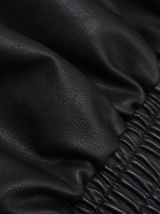 Detailed macro view of black PU leather texture with elasticated ribbed hem and cuffs