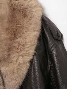 Detailaufnahme der braunen Kunstlederjacke mit hochwertiger Textur und Pelzkragenbesatz