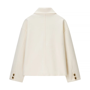 Detailansicht der beigen Wolljacke mit Nahtlinien und dunklen Knöpfen an den Bündchen