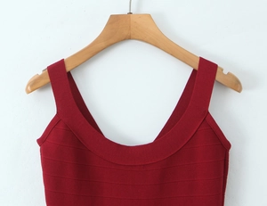 Close-up of deep red knitted dress featuring a deep U-neckline and ribbed texture