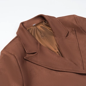 Détail du col d'un manteau en velours rouille avec doublure en satin et coutures soignées