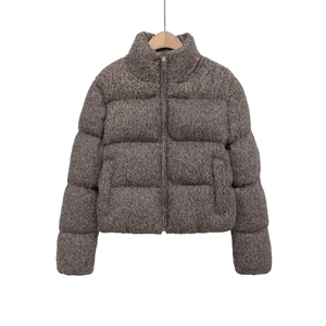 Detail of high stand collar and tweed texture on warm thickened winter jacket for women