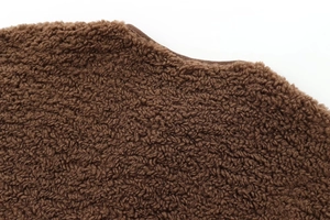 Vue détaillée de la texture polaire sherpa marron foncé et des coutures de l'ourlet