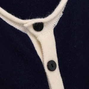Women's knit sweater with contrast piping and dark buttons in navy blue and cream