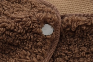 Vue détaillée de la texture polaire peluche marron foncé et bouton métallique sur la veste