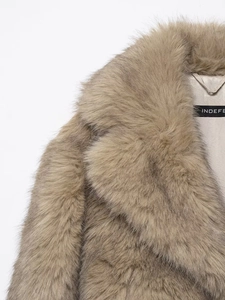 Détail d'un manteau en fausse fourrure avec doublure en satin et étiquette INDEFE