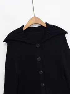 Detailansicht der dunklen Rippstrickjacke mit großen runden Knöpfen und breitem Kragen