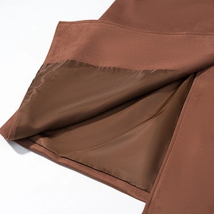 Détail de la texture en daim marron foncé avec doublure en satin et coutures précises