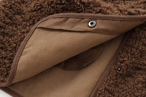 Détail de la veste en polaire teddy marron avec bouton métallique et doublure