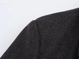 Close-up of padded shoulder seams and textured wool fabric on a gray blazer