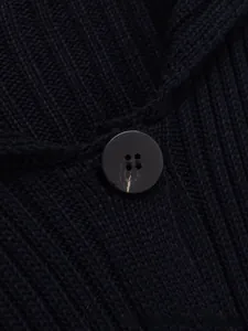 Detail der Rippstrick-Struktur und matter schwarzer Knopf auf dunkelblauer Strickjacke