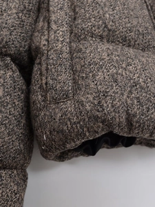 Macro shot of thick tweed winter jacket showing side pocket and premium knit texture