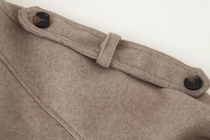 Detailed macro view of camel wool coat shoulder strap with tortoiseshell buttons