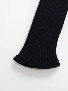 Detailaufnahme des schwarzen Rippstrick-Ärmels mit vertikaler Webstruktur