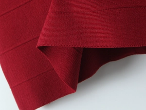 Detailed close-up of premium red knit fabric showing thick horizontal bandage texture
