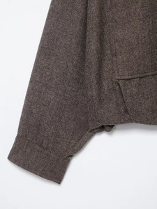 Detail of brown herringbone tweed jacket showing premium cuff and pocket stitching