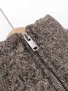 Detail of the high-quality metal zipper and thick knit texture on this warm winter jacket