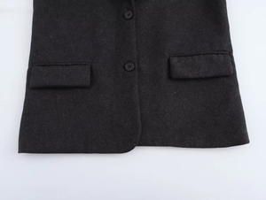 Detail of dark gray wool blend suit jacket showing buttons and flap pocket texture