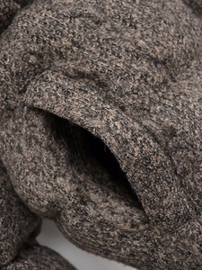 Macro shot of the side pocket and thick textured knit fabric on this winter jacket