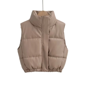 Detailed close-up of khaki faux leather quilted vest with high collar and puffy seams
